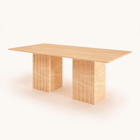 The Ridge Rectangular Travertine Dining Table by Travertable showcases modern sophistication with fluted pedestal legs and a smooth, light wood finish set against a plain white background.