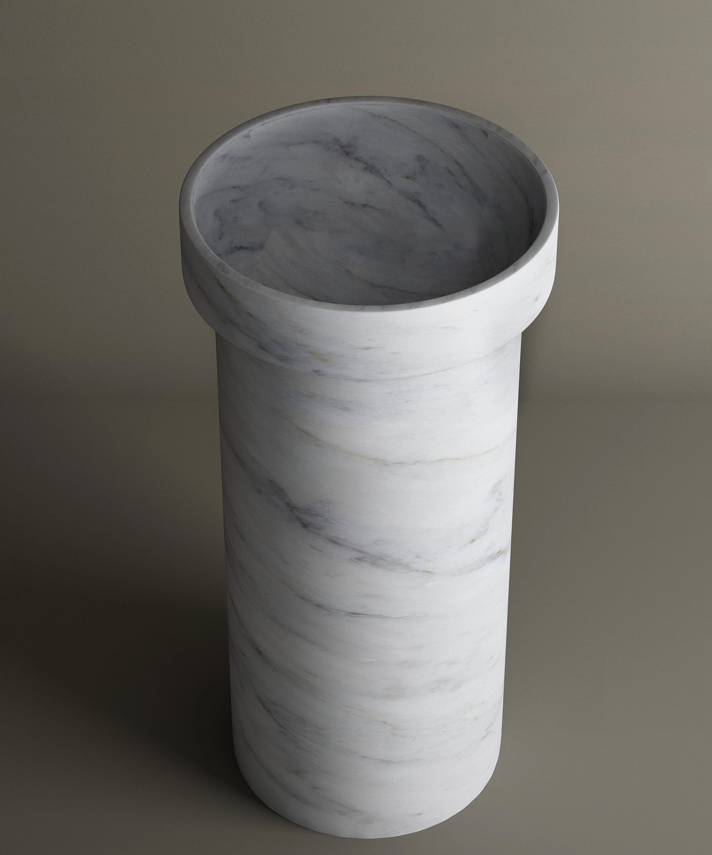 The TRAVERTABLE Carrara Marble Pedestal Vanity Sink features a cylindrical design with a wide opening and thick rim. Its white marble base with subtle grey veining brings refined style and timeless elegance to any bathroom interior.