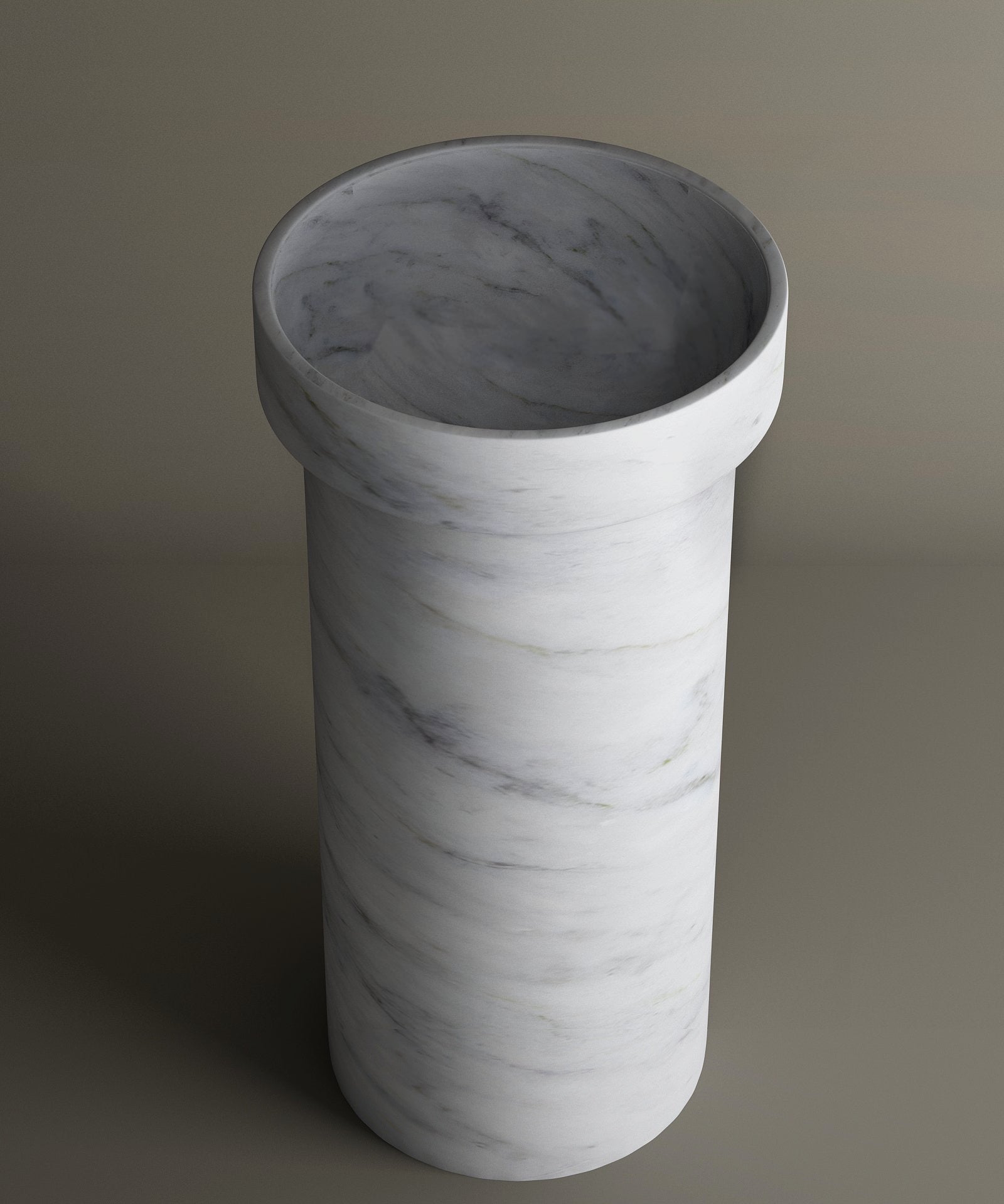 The TRAVERTABLE Carrara Marble Pedestal Vanity Sink features a cylindrical design with a wide opening and thick rim. Its white marble base with subtle grey veining brings refined style and timeless elegance to any bathroom interior.