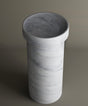 The TRAVERTABLE Carrara Marble Pedestal Vanity Sink features a cylindrical design with a wide opening and thick rim. Its white marble base with subtle grey veining brings refined style and timeless elegance to any bathroom interior.
