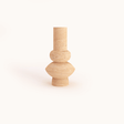 The Travertable Minimalist Beige Travertine Vase features a minimalist design with a tall cylindrical neck, rounded middle, and small circular base in unglazed travertine stone, all set against a plain white background.
