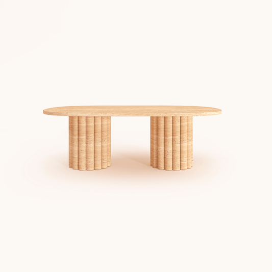 The Handcrafted Italian Travertine Coffee Table by Travertable features an oval top with two cylinder-shaped column legs. The expert craftsmanship and light finish highlight its natural beauty, set against a plain white background.