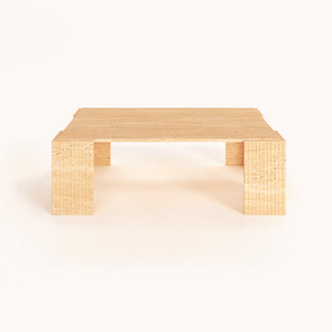 The Modern Rustic Travertine Coffee Table by Travertable, featuring block-style legs and a minimalist design, balances raw texture with refined form and showcases its natural beauty against a plain white background.