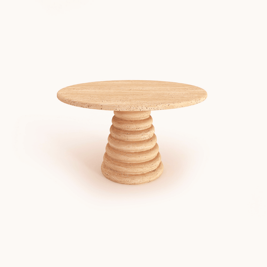 The Travertable Designer Travertine Marble Coffee Table features sculptural stone aesthetics and a unique geometric base with stacked layers, highlighting its natural beauty against a plain white background.