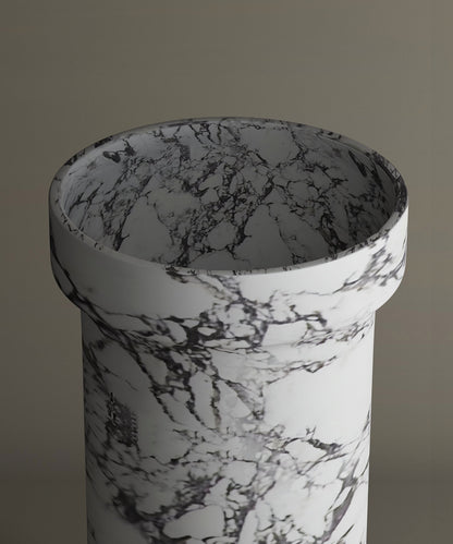 The TRAVERTABLE Calacatta Marble Pedestal Vanity Sink features striking dark gray veining on white marble, offering timeless elegance against a neutral backdrop.