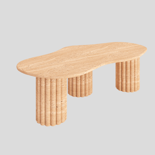 The Terra Solace Travertine Coffee Table by Travertable, featuring a beige oval top and wavy design, showcases its natural beauty. Its textured stone-like surface and cylindrical column legs highlight expert craftsmanship against a simple gray backdrop.