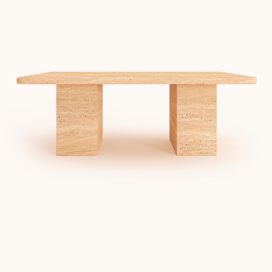 Travertable’s Limestone Luxury Coffee Table offers a timeless, minimalist design. It features a sculptural rectangular shape crafted from light-colored travertine stone, standing on two solid block supports. Its smooth surface stands out elegantly against a white background, highlighting its natural beauty.