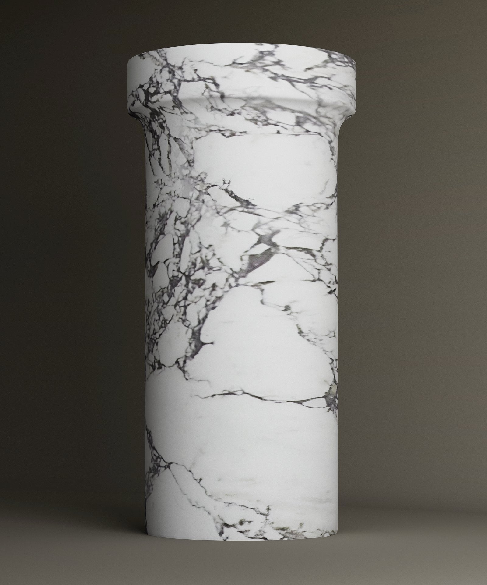 The TRAVERTABLE Calacatta Marble Pedestal Vanity Sink features a tall, cylindrical design with a wider top and elegant gray veining. The plain backdrop accentuates its timeless, sophisticated look.