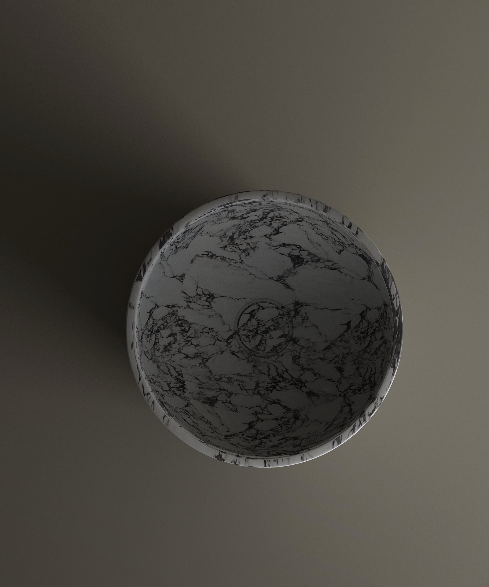 The TRAVERTABLE Calacatta Marble Pedestal Vanity Sink features a round design with a gray and black marbled pattern, viewed from above atop a matte surface that creates a subtle shadow to the left.