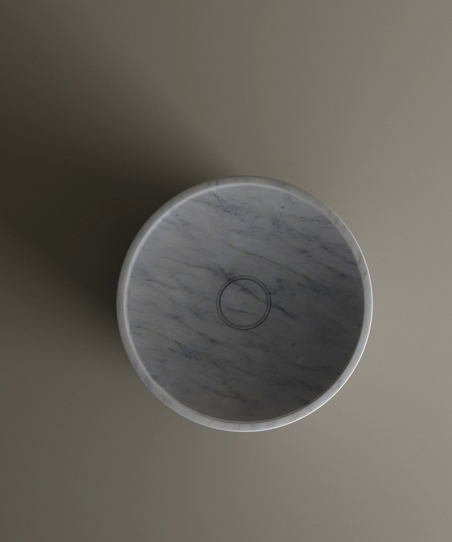 The TRAVERTABLE Carrara Marble Pedestal Vanity Sink features a round, gray design with subtle veining, centered on a matte surface and viewed from above—a sophisticated choice for elegant interiors.