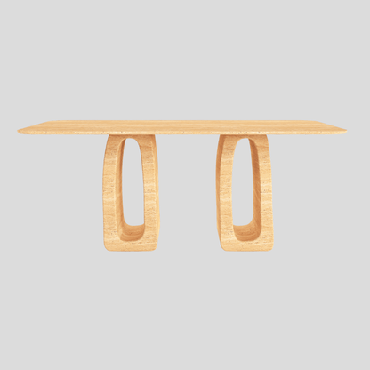 The Arcadia Travertine Dining Table by Travertable boasts a smooth top and two oval, hollow legs against a light gray backdrop. Its modern design is artistic and minimalist, seamlessly merging symmetry with elegance.