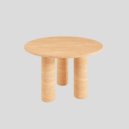 The Trio Round Travertine Dining Table by Travertable features a smooth travertine top and three cylindrical legs, set against a plain light gray background.
