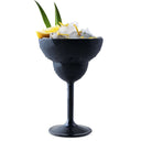 A Mamaco Home Unbreakable Margarita Glass, crafted from polycarbonate, holds ice and lemon slices, garnished with green leaves. Water droplets grace the sleek black surface.