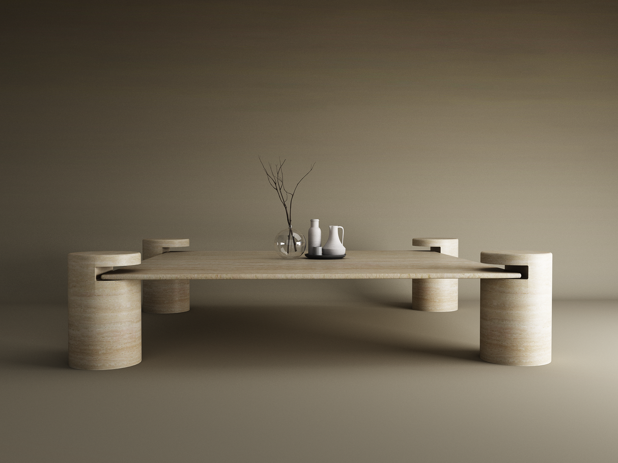 The TRAVERTABLE Square Travertine Coffee Table with Cylindrical Legs, crafted from pure travertine stone, stands against a beige backdrop. On it are a clear vase with twigs and two ceramic pitchers in white and gray for a touch of modern elegance.