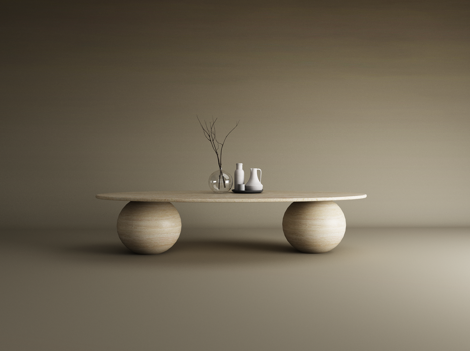 The TRAVERTABLE Ellipse Travertine Coffee Table with Stone Ball Base features a smooth, oval top and sculptural stone bases, styled with a glass vase of bare branches and two white ceramic pitchers on a black tray against a beige backdrop.