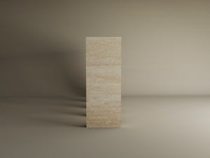 A travertine console table with four arches by TRAVERTABLE stands upright in a neutral-toned room, its beige stone surface showcasing refined craftsmanship as soft shadows fall to the left.