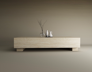 A TRAVERTABLE Rectangular Travertine Coffee Table with Hidden Base stands on a smooth floor. A clear glass vase with bare branches and two white ceramic vessels rest on top, while the plain background complements the calm, neutral vibe.