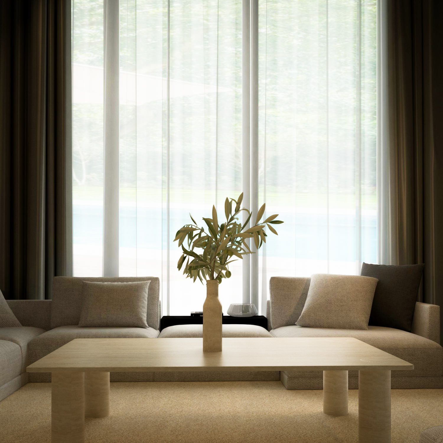 A minimalist living room with neutral sofas features the TRAVERTABLE Rectangular Travertine Coffee Table with Solid Cylindrical Base in warm stone, plus a vase of green branches. Sheer-curtained windows fill the space with light and frame lush outdoor greenery.