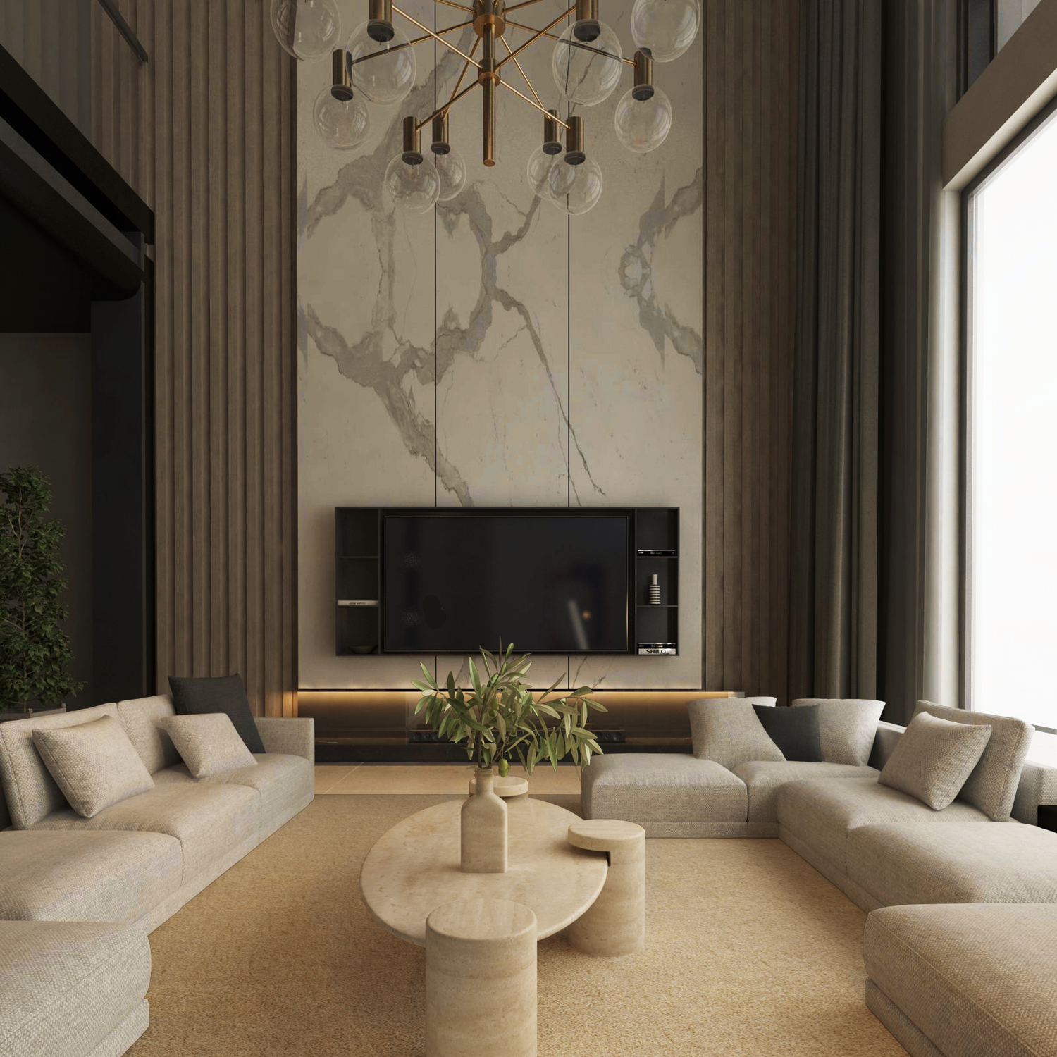 A modern living room with L-shaped beige sofas around the TRAVERTABLE Ellipse Travertine Coffee Table featuring a cylindrical base and soft organic form, a beige rug, marble accent wall with TV, large curtained window, and gold chandelier.