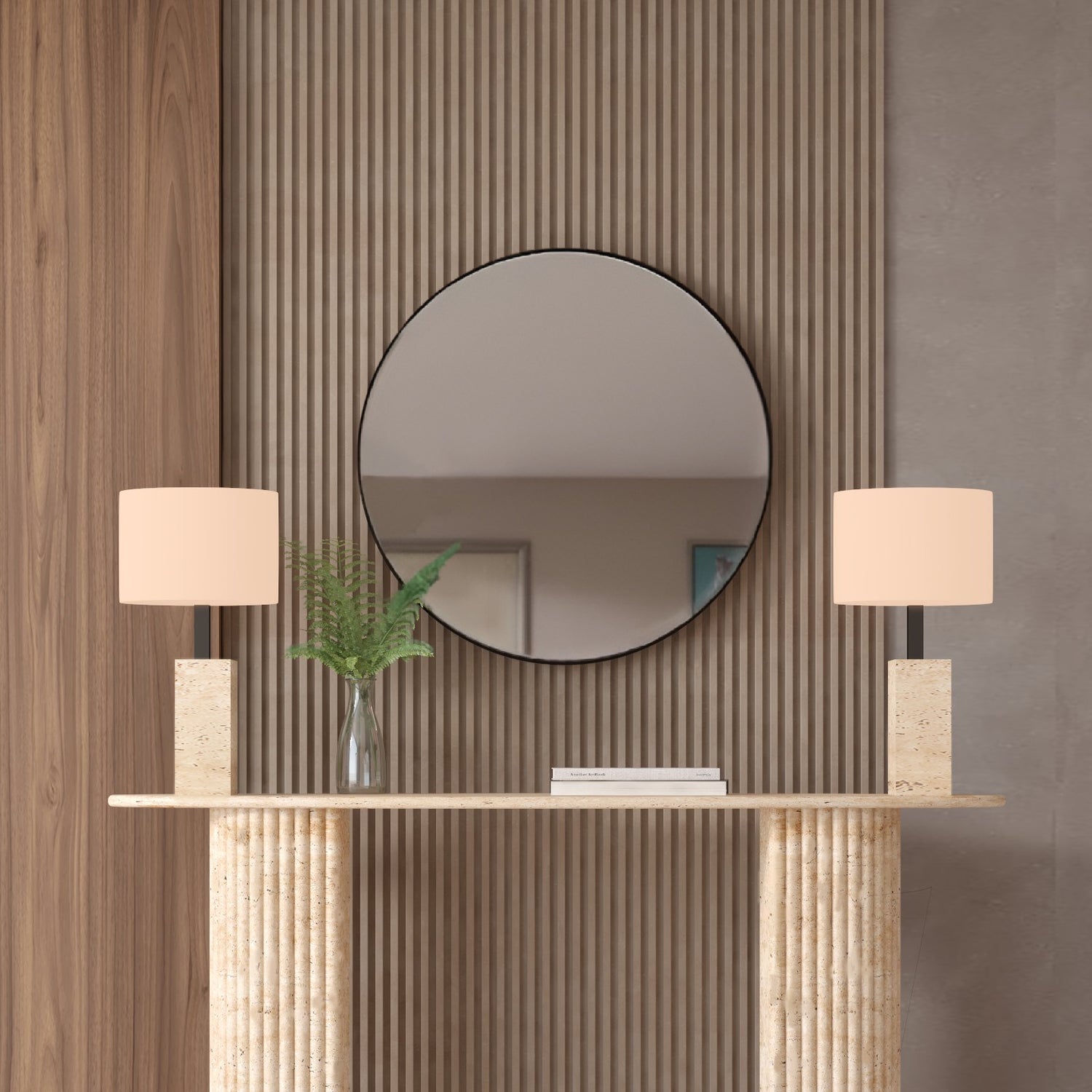 The TRAVERTABLE Ovale Travertine Console Table with a fluted round base stands against vertical wood panels beneath a large mirror, paired with matching lamps and green ferns for a modern minimalist look with natural texture.