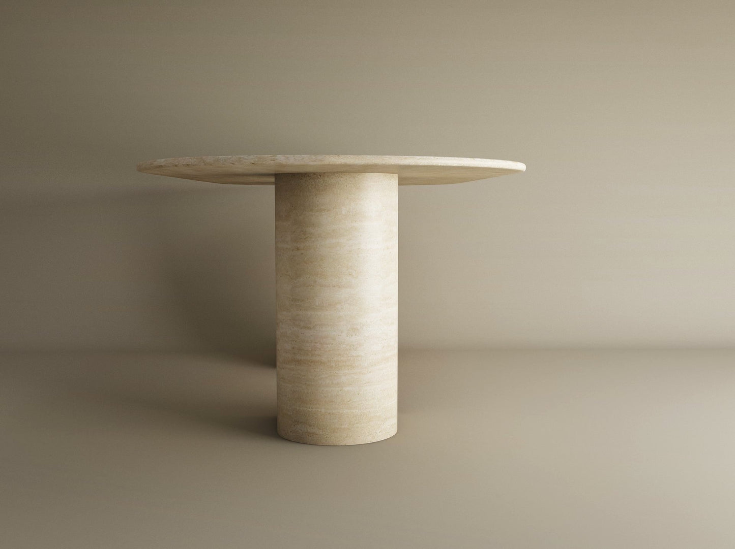 The TRAVERTABLE Oval Travertine Dining Table features a sloped natural stone pedestal base and matching tabletop in light beige, creating a timeless, customizable heirloom piece to elevate any space.