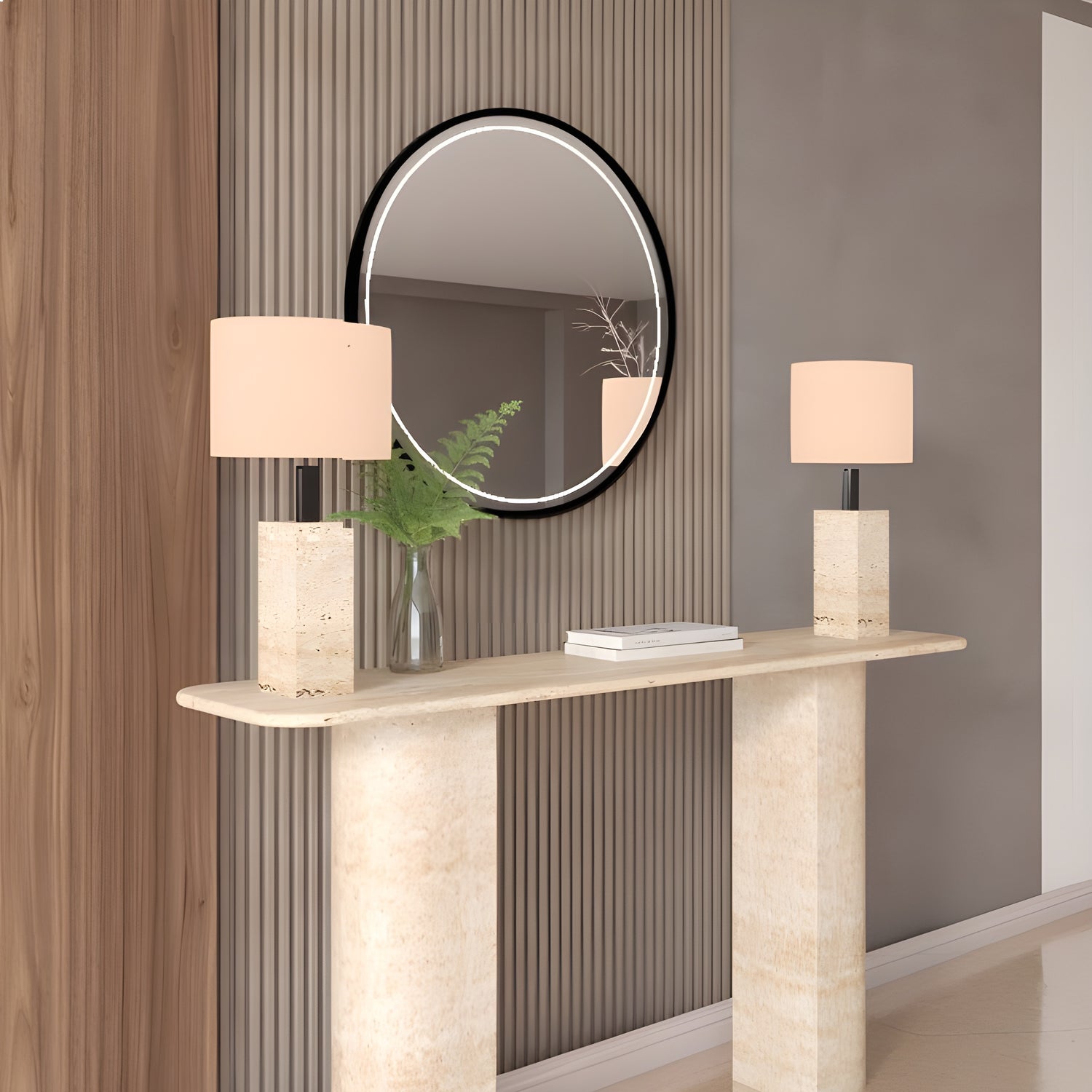 A modern entryway with the TRAVERTABLE Rectangular Travertine Console Table featuring a sloped pedestal base, paired with two beige-shaded lamps, a round wall mirror, and a glass vase on grooved and smooth wall panels.