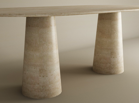 The TRAVERTABLE Oval Travertine Dining Table features a smooth, natural stone tabletop and conical pedestal bases in light beige, creating a seamless look with matching surroundings. Customizable to fit your dining space.