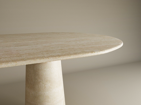 A close-up of the TRAVERTABLE Oval Travertine Dining Table, featuring an organic travertine stone tabletop and a conical pedestal base, shown against a neutral background. Customizable to suit your dining needs.