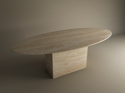 The TRAVERTABLE Ellips Travertine Dining Table features a thick natural stone tabletop and block base in beige, set against a plain neutral background. This customizable dining table combines elegance and durability.