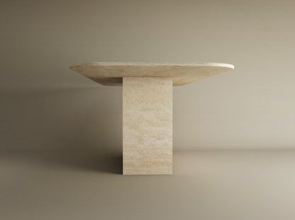 The TRAVERTABLE Rectangular Travertine Dining Table features a thick natural stone top and solid block base, showcasing a timeless, minimalist design in light neutral tones. Customizable to fit your dining space.