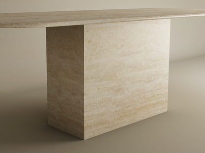The TRAVERTABLE Rectangular Travertine Dining Table features a natural stone tabletop and block base, offering a timeless, customizable design that complements neutral spaces with its solid build and smooth surface.