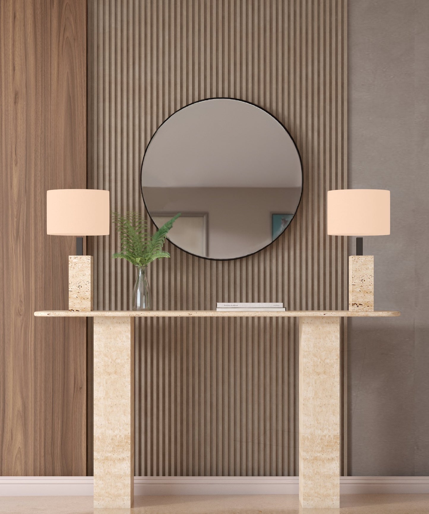 A TRAVERTABLE Rectangular Travertine Console Table with a travertine stone base displays two rectangular-based lamps, a glass vase with green ferns, and stacked books. A round mirror hangs on a wall of vertical wooden slats behind it.