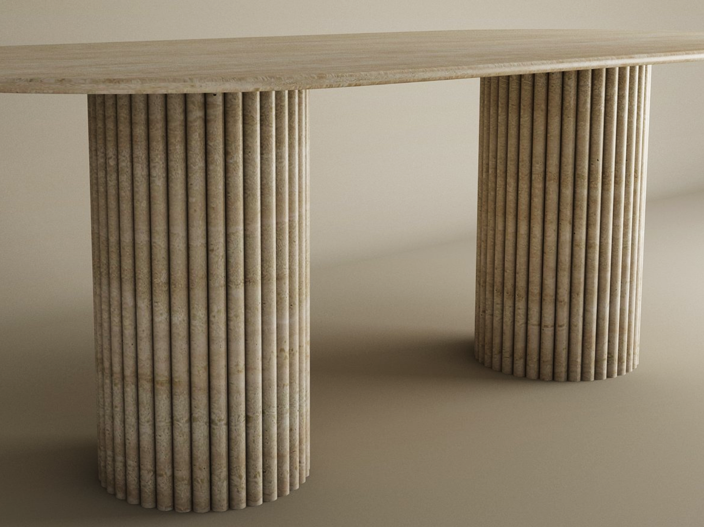 The TRAVERTABLE Oval Travertine Dining Table features a natural stone tabletop and two fluted, vertical groove bases. Its plain, neutral background highlights this customizable heirloom piece’s timeless design.