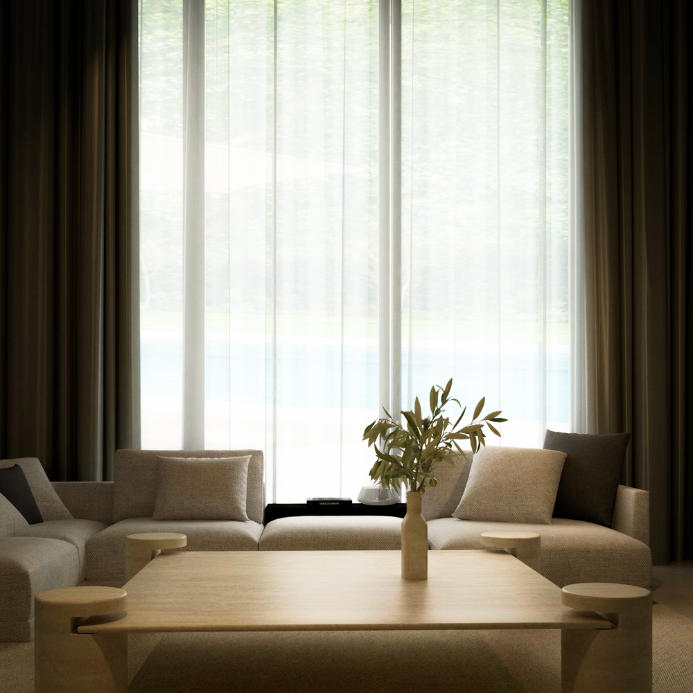 A modern living room features the TRAVERTABLE Square Travertine Coffee Table with Cylindrical Legs, crafted from pure travertine stone. Surrounded by beige sofas and neutral pillows, floor-to-ceiling windows with sheer curtains fill the space with soft light.