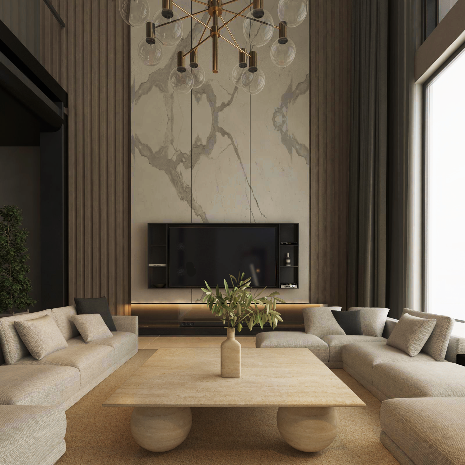 A modern living room showcases a marble wall, mounted TV, and long beige sofas around the TRAVERTABLE Square Travertine Coffee Table with Stone Ball Base. A minimal vase with greenery, tall windows, and a gold chandelier complete the elegant space.