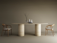Minimalist dining setup showcasing the TRAVERTABLE Ellips Travertine Dining Table with a smooth cylinder base and pure travertine stone, paired with two wooden chairs with white cushions and decorative vases against a neutral beige background.