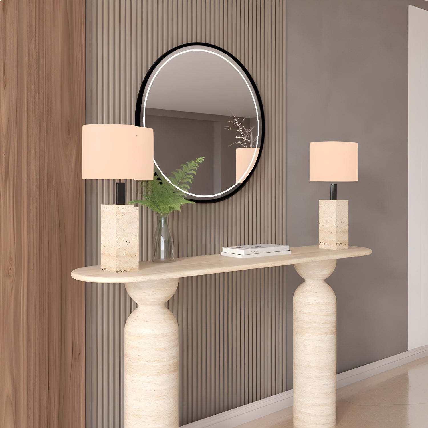 A modern entryway featuring the TRAVERTABLE Ovale Travertine Console Table with a sculptural organic travertine stone base, two beige lamps, a round black-framed mirror, green fern leaves in a glass vase, and vertical wood and taupe wall panels.