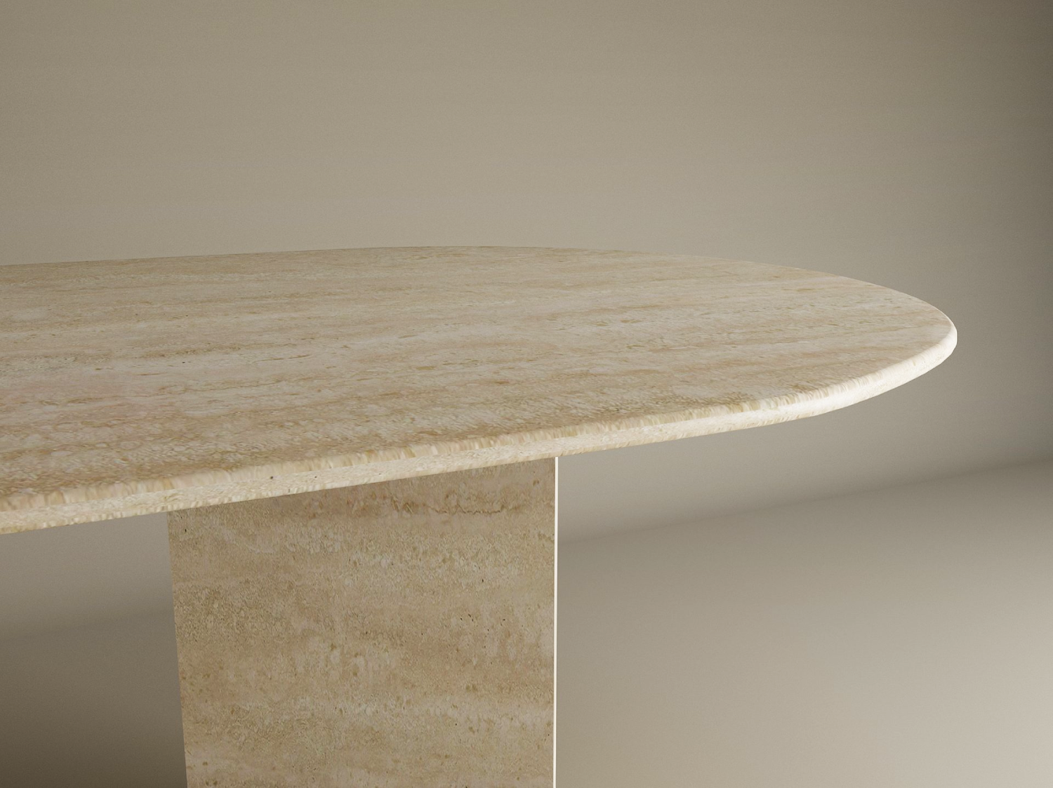 A close-up of the TRAVERTABLE Oval Travertine Dining Table features a thick natural stone top and a split-V pedestal travertine base, set against a plain light background. Customizable options available.