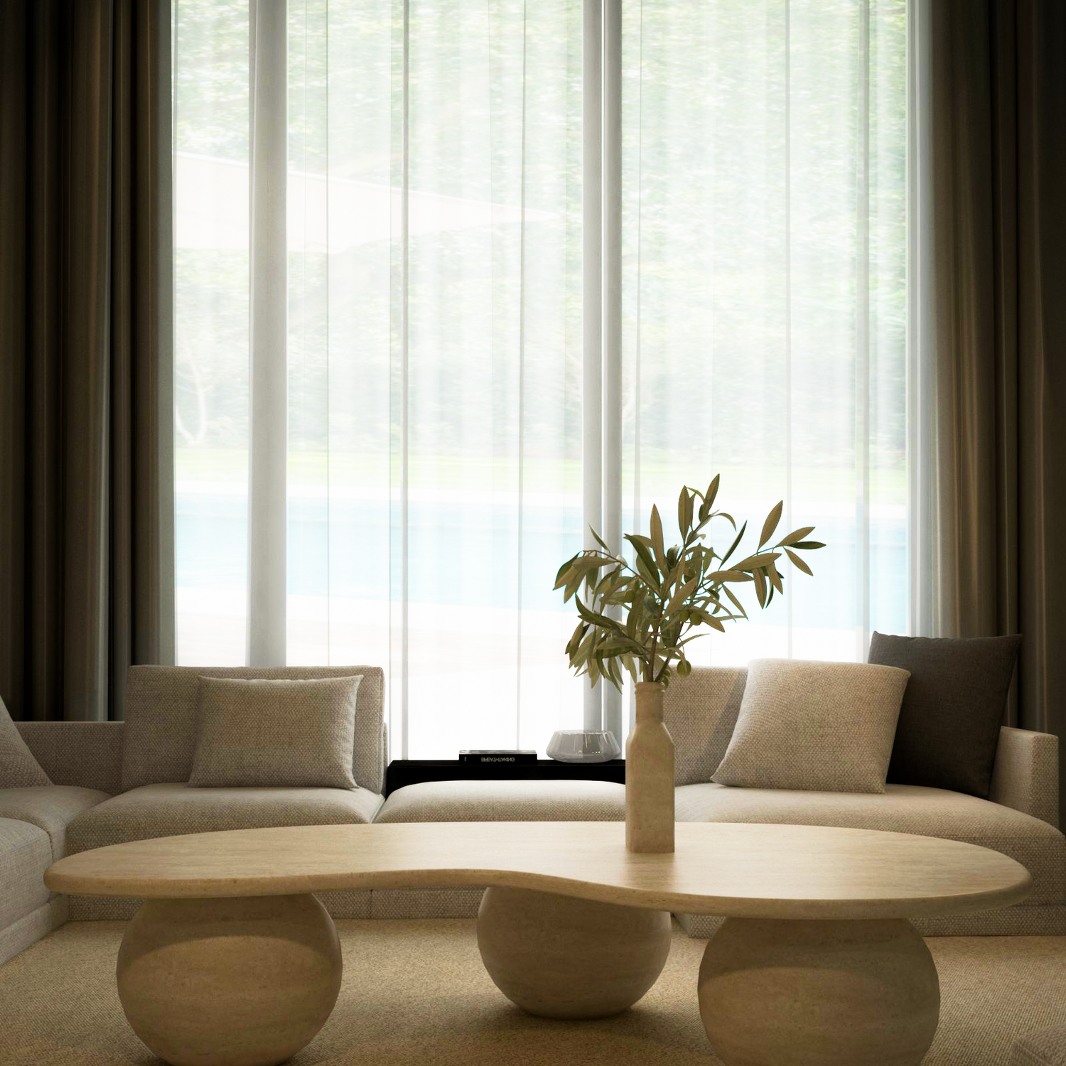A modern living room features beige sofas and the TRAVERTABLE Wavy Travertine Coffee Table with Stone Ball Base—an organic, customizable piece topped with a vase of green branches. Sheer white curtains fill the minimalist space with soft natural light.