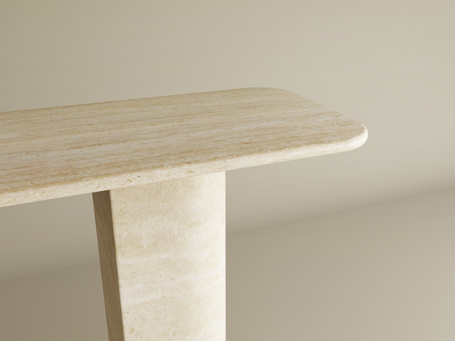 Close-up of the TRAVERTABLE Rectangular Travertine Console Table featuring a natural stone finish, rounded corners, and a unique sloped pedestal base, shown against a smooth neutral background. Customizable to suit your space.