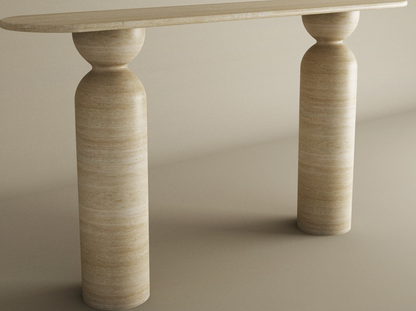 The Ovale Travertine Console Table by TRAVERTABLE features an elongated oval top, a sculptural round base, and cylindrical stone legs with sphere accents in organic travertine—a customizable statement piece.