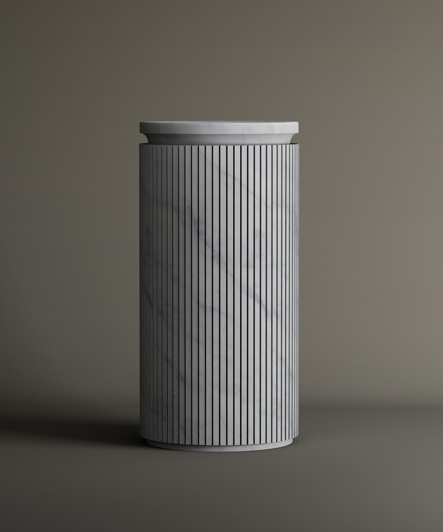 The TRAVERTABLE Carrara Round Marble Pedestal Vanity Sink features a tall, cylindrical form with vertical grooves and smooth Carrara marble surface, highlighted by subtle gray veining against a neutral background.