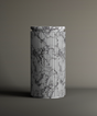 The TRAVERTABLE Calacatta Round Marble Pedestal Vanity Sink, featuring a marble pattern and vertical grooves inspired by Italian design, is displayed on a plain surface with a neutral background.