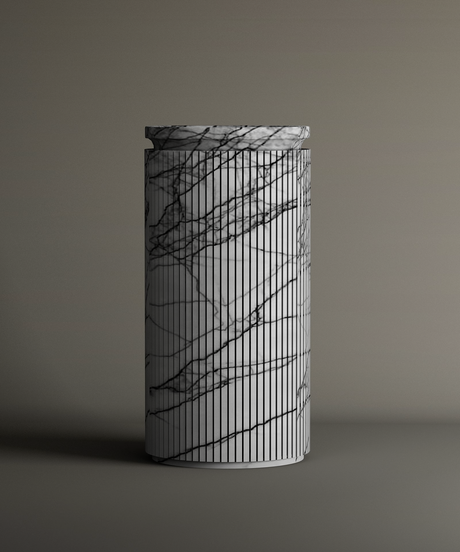 The Lilac Round Marble Pedestal Vanity Sink by TRAVERTABLE features a cylindrical marble design with vertical black lines and a matching lid, exuding sculptural elegance against a neutral backdrop.