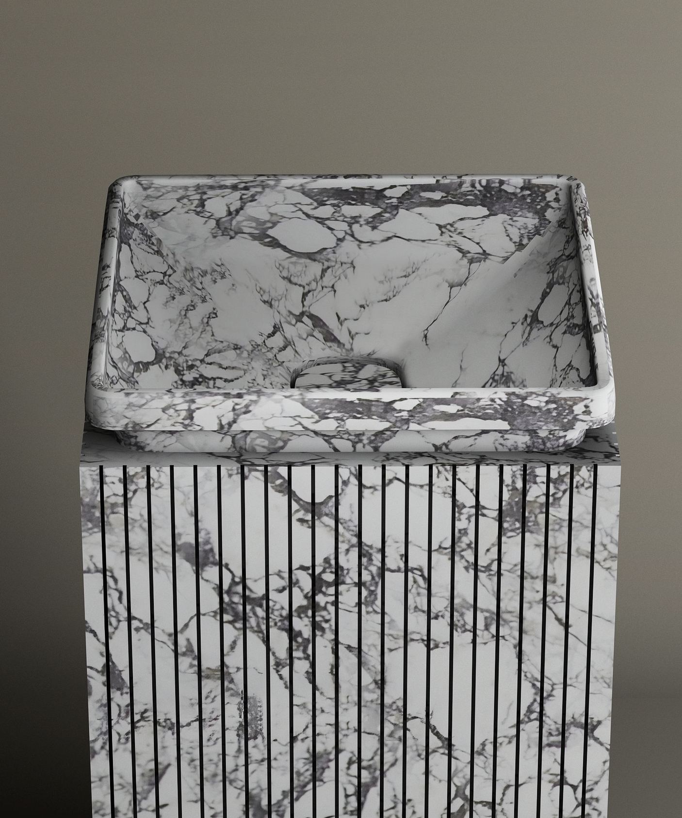 The TRAVERTABLE Calacatta Square Marble Pedestal Vanity Sink, with gray and black veining and vertical grooves, creates a bold marble centerpiece against a plain gray background.
