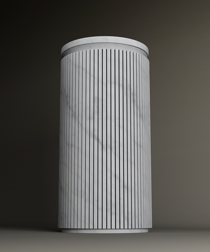 The TRAVERTABLE Carrara Round Marble Pedestal Vanity Sink features vertical black lines on a white, Carrara marble-like surface and stands upright against a plain, dark background.