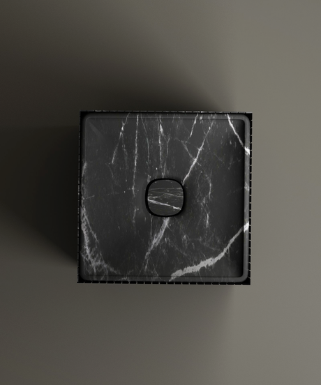 The TRAVERTABLE Nero Marquina Square Fluted Marble Pedestal Vanity Sink, featuring white veining and a central round drain cover, is shown from above against a plain grey background with shadows falling to the left.
