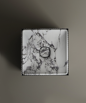 The TRAVERTABLE Calacatta Square Fluted Marble Pedestal Vanity Sink features a white marble design with bold dark veining, matching drain cover, and straight edges, shown from above on a matte surface.