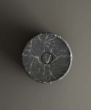 The TRAVERTABLE Nero Marquina Round Marble Pedestal Vanity Sink features smooth edges, dramatic white veining on black marble, and a central drain. Shown from above against a plain gray background, it’s perfect for bathroom design.