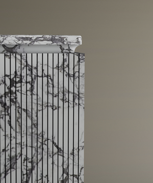 A partial view of the TRAVERTABLE Calacatta Square Marble Pedestal Vanity Sink, showcasing black vertical lines and gray veining, makes a striking centerpiece for modern bathrooms. Its flat rectangular top is set against a plain beige background.